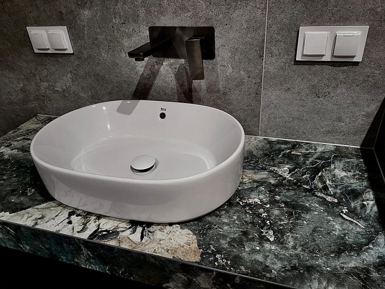 Designerska umywalka nablatowa Roca na marmurowym blacie — wykończenie wnętrz